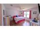Bright bedroom with a colorful decor, including a vibrant bedspread, striking wooden floors, and natural light at 17930 Se 83Rd Melody Ave, The Villages, FL 32162