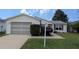 Charming single-story home featuring a well-maintained lawn and attached one-car garage at 17930 Se 83Rd Melody Ave, The Villages, FL 32162