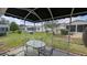 View from covered lanai with outdoor seating, overlooking manicured lawn and neighboring homes at 17930 Se 83Rd Melody Ave, The Villages, FL 32162