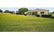Sprawling backyard with well-maintained grass and a view of the rear exterior at 17985 Se 102Nd Ct, Summerfield, FL 34491