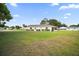 Spacious backyard with a well-maintained lawn and a screened lanai at the back of the house at 17985 Se 102Nd Ct, Summerfield, FL 34491