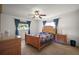Charming bedroom with a wooden bed frame, blue quilt, matching dresser, and curtains at 17985 Se 102Nd Ct, Summerfield, FL 34491