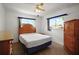 Comfortable bedroom with a wooden bed frame, neutral colors, and natural light, creating a cozy and relaxing atmosphere at 17985 Se 102Nd Ct, Summerfield, FL 34491