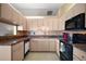 Efficient kitchen featuring wood cabinets, essential appliances, and functional layout, providing convenience for cooking at 17985 Se 102Nd Ct, Summerfield, FL 34491