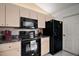 This kitchen features a black microwave, stove, and refrigerator adding sophistication and functionality to the cooking space at 17985 Se 102Nd Ct, Summerfield, FL 34491