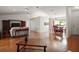 Open-concept living room showcasing wood floors, a sofa, and a dining area with natural light, creating a welcoming space at 17985 Se 102Nd Ct, Summerfield, FL 34491