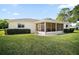 Well-maintained home exterior featuring a screened lanai and lush lawn at 17985 Se 102Nd Ct, Summerfield, FL 34491