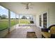 Enclosed sunroom with tile flooring, ceiling fan, and views of the landscaped yard at 17985 Se 102Nd Ct, Summerfield, FL 34491