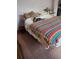 Bright bedroom with bed and colorful, rainbow chevron patterned blanket at 1805 Ne 29Th Pl, Ocala, FL 34479