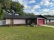 Charming single-story home featuring a red garage door and lush green lawn at 1805 Ne 29Th Pl, Ocala, FL 34479