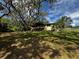 Large, verdant backyard with mature oak trees shading the lawn and views of the home's rear facade at 18130 Keene Rd, Altoona, FL 32702