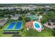 Expansive community aerial view featuring tennis courts, pool, lush landscaping and many houses at 1860 Park Forest Blvd, Mount Dora, FL 32757