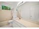 Bathroom showcasing a white vanity with a countertop, an oversized mirror, and a window at 1860 Park Forest Blvd, Mount Dora, FL 32757