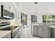 Kitchen features modern stainless steel appliances, quartz countertops, and backyard views with pool at 1860 Park Forest Blvd, Mount Dora, FL 32757