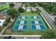 Aerial view of pickleball courts, adjacent tennis courts, and houses in a lovely neighborhood at 1860 Park Forest Blvd, Mount Dora, FL 32757