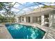 A refreshing screened-in pool surrounded by a patio and lush landscaping for outdoor enjoyment at 1860 Park Forest Blvd, Mount Dora, FL 32757