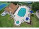 Aerial view of sparkling swimming pool with lounge chairs, tables, and umbrellas at 1860 Park Forest Blvd, Mount Dora, FL 32757