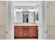 Vanity with double sinks, vanity lighting, and wood cabinets in this primary ensuite bathroom at 1871 W Schwartz Blvd, Lady Lake, FL 32159