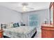 Cozy bedroom featuring neutral walls, a ceiling fan, a window, and furnishings at 1871 W Schwartz Blvd, Lady Lake, FL 32159