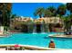 Resort-style pool with waterfall feature and lush tropical landscaping on a sunny day at 1871 W Schwartz Blvd, Lady Lake, FL 32159