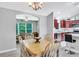 Bright dining room with wood table set, chandelier lighting, and view into the kitchen and living area at 1871 W Schwartz Blvd, Lady Lake, FL 32159