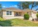 Inviting front exterior with a small sitting area, manicured lawn, and a well-maintained landscape at 1871 W Schwartz Blvd, Lady Lake, FL 32159