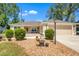 Lovely home with a meticulously landscaped front yard and a cozy front patio with chairs at 1871 W Schwartz Blvd, Lady Lake, FL 32159