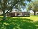 Expansive backyard with mature trees and screened lanai at 1875 Oxford Ln, The Villages, FL 32162