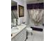 Traditional bathroom featuring a single sink vanity with framed mirror and a shower-tub combo with patterned curtain at 1875 Oxford Ln, The Villages, FL 32162