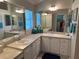 Bathroom featuring double sinks, mirrored cabinets, and a large window for a bright and airy feel at 1875 Oxford Ln, The Villages, FL 32162