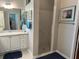Well-lit bathroom featuring modern white cabinets, dual sinks, and a walk-in shower at 1875 Oxford Ln, The Villages, FL 32162