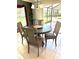 Dining area featuring a round table and chairs, with natural light, and an entrance to the screened-in lanai at 1875 Oxford Ln, The Villages, FL 32162