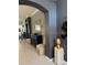 Decorated entryway featuring neutral tones, an accent table and arched doorway to the living area at 1875 Oxford Ln, The Villages, FL 32162