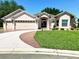 Charming single-story home featuring a well-manicured lawn, ample parking and a covered front entrance at 1875 Oxford Ln, The Villages, FL 32162