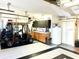 Well-organized garage featuring a golf cart, storage cabinets, and refrigerator for convenience at 1875 Oxford Ln, The Villages, FL 32162