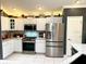 Bright kitchen showcasing white cabinets, stainless steel appliances, and sleek granite countertops at 1875 Oxford Ln, The Villages, FL 32162