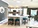 Well-equipped kitchen features an island with bar seating, stainless steel appliances, and bright white cabinetry at 1875 Oxford Ln, The Villages, FL 32162