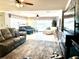 Cozy living room with plush sofas, patterned rug, natural light, and modern entertainment center at 1875 Oxford Ln, The Villages, FL 32162