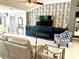 Inviting living room featuring a stylish accent wall, cozy seating, and a sleek entertainment center at 1875 Oxford Ln, The Villages, FL 32162