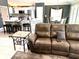 Open concept living area with sofa, tiled floors, kitchen island and bar stool seating at 1875 Oxford Ln, The Villages, FL 32162