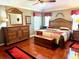 Spacious main bedroom with wood flooring, a ceiling fan, and a decorative furniture set at 1875 Oxford Ln, The Villages, FL 32162