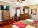 Inviting main bedroom with wood floors, ample closet space, and a view of the yard through the window at 1875 Oxford Ln, The Villages, FL 32162