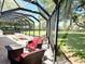 This screened-in patio boasts ample seating and dining areas, with a view of the lush, green backyard at 1875 Oxford Ln, The Villages, FL 32162