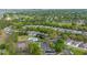 Scenic aerial view of community with pool, tennis court, mature trees, and well-maintained landscaping at 2012 Braxton St, Clermont, FL 34711