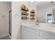 Well-lit bathroom featuring a modern vanity, decorative shelving, and a glass-enclosed shower at 2012 Braxton St, Clermont, FL 34711