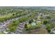Aerial view of the community, featuring a pool, tennis court, green space, and mature trees at 2012 Braxton St, Clermont, FL 34711