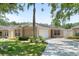 Charming one-story home with lush green lawn and mature landscaping, featuring a two-car garage and welcoming entrance at 2012 Braxton St, Clermont, FL 34711