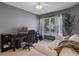 This home office offers a comfortable workspace with a daybed, natural light and neutral tones at 2012 Braxton St, Clermont, FL 34711
