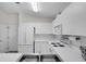 Bright kitchen features all-white appliances and cabinetry, tile floors, and ample counter space with modern fixtures at 2012 Braxton St, Clermont, FL 34711