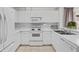 Bright kitchen features all-white appliances and cabinetry, tile floors, and ample counter space with modern fixtures at 2012 Braxton St, Clermont, FL 34711